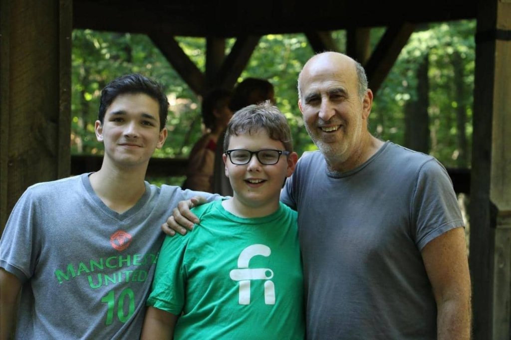 Adam Simon with two teens at camp