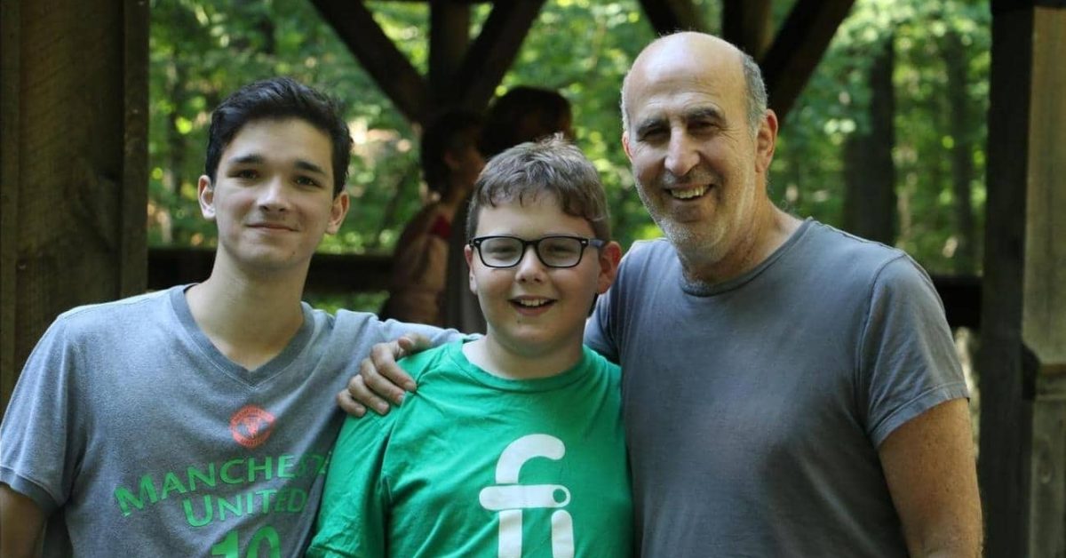 Adam Simon with two teens at camp