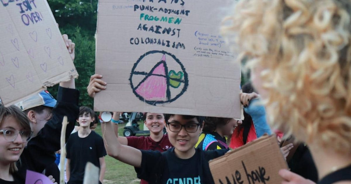 Teen holds up a protesting sign