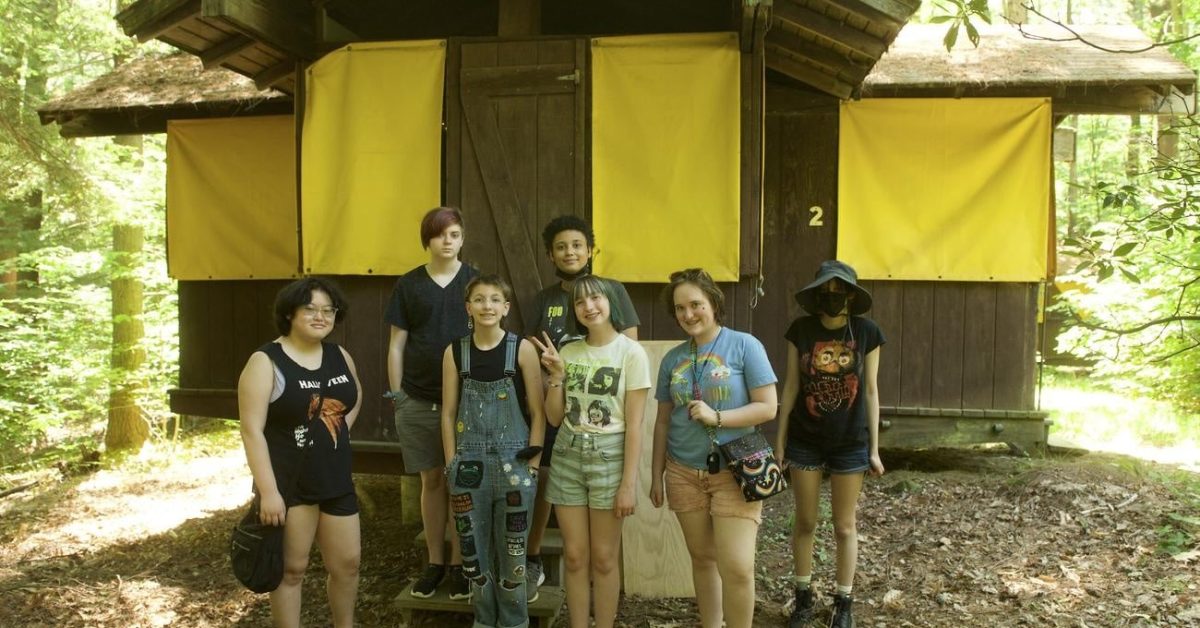 Group of gender diverse teens outside of their cabin