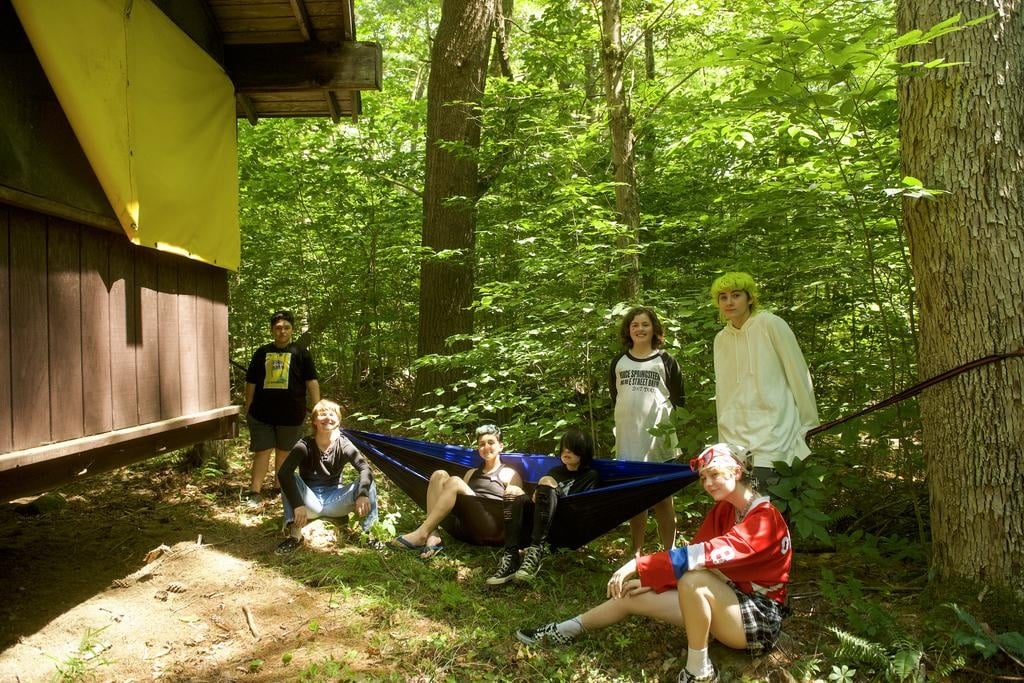 Gender diverse campers in front of their cabins