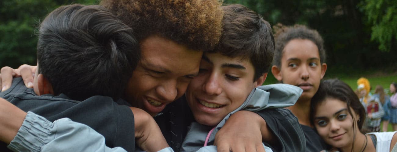 Teen campers hugging