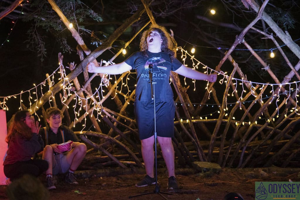 Teen camper sings his heart out at en evening performance.