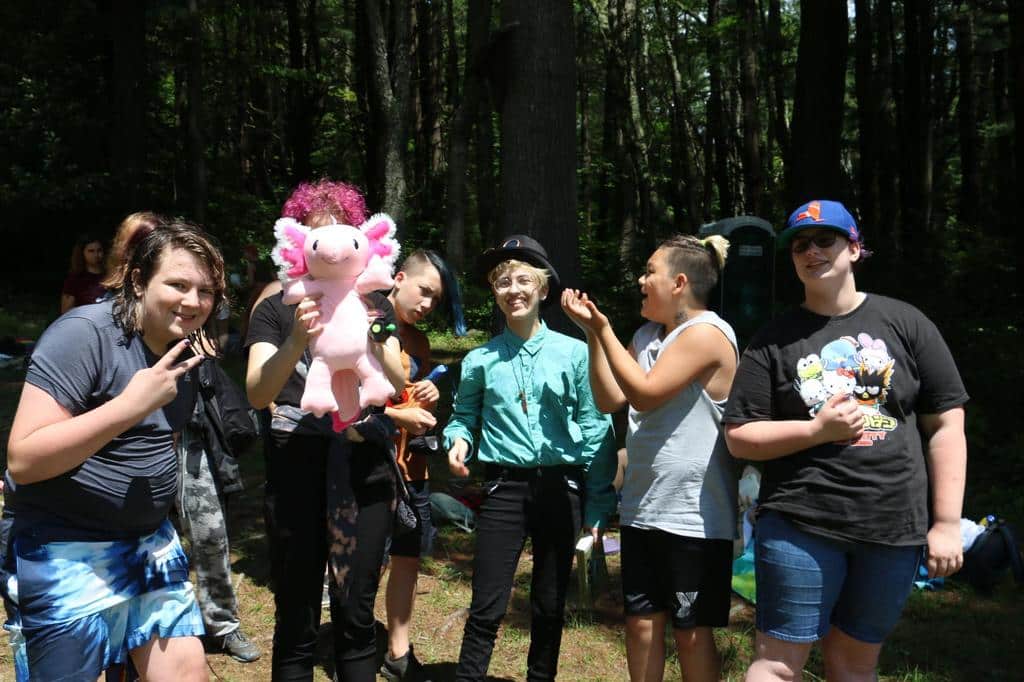 Teen camper showing off his puppet in group photo