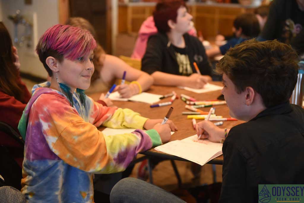 Campers conversing while drawing in the art hut.