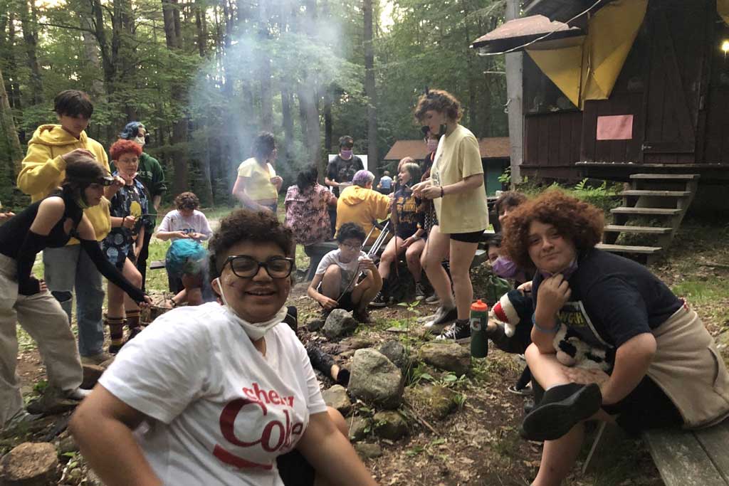 Teens have a BBQ outside their cabins
