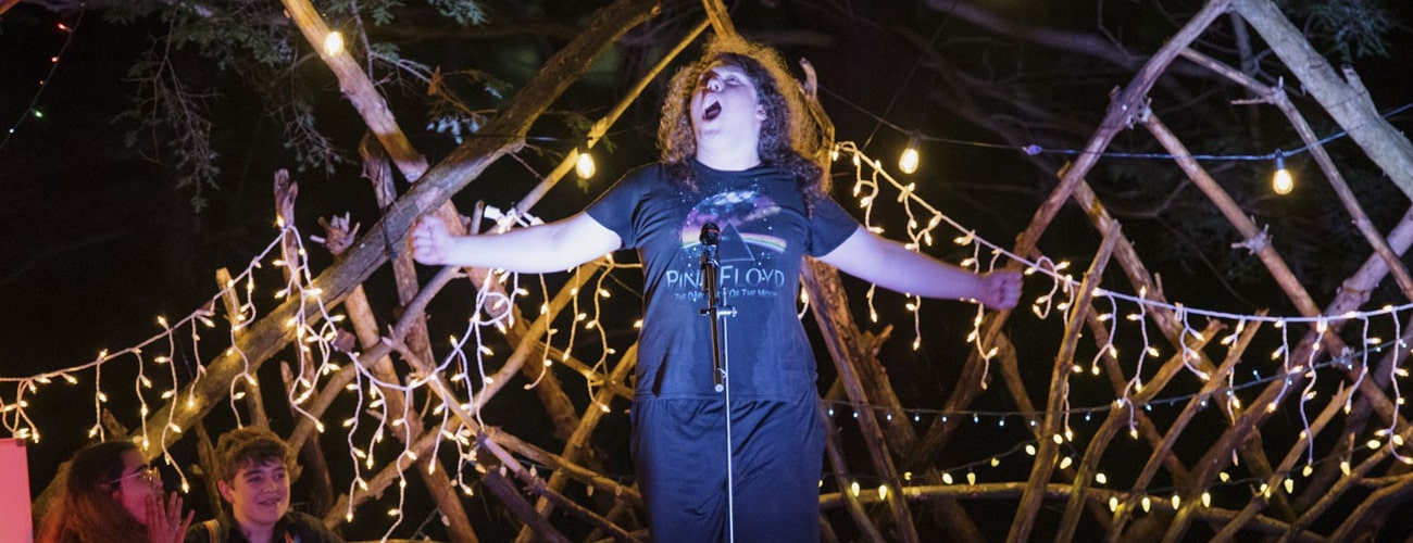 Teen camper sings his heart out at en evening performance.