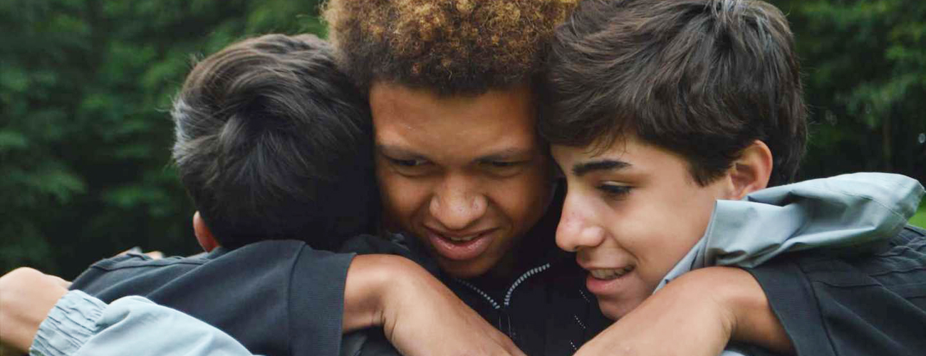 Three teens hugging on the last day of camp.