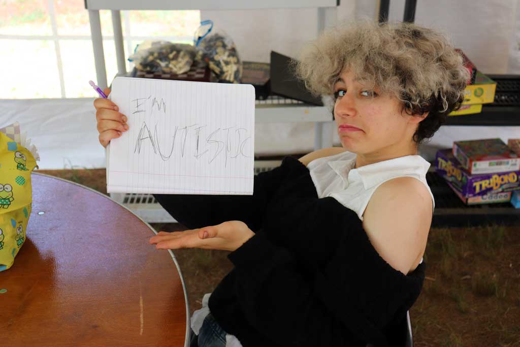 Teen holds sign in humorous way that says "i'm autistic."