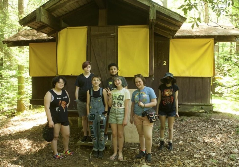 Group of gender diverse teens outside of their cabin