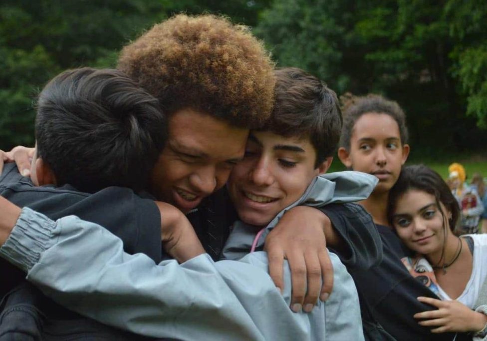 Group of teens hug goodbye intensely